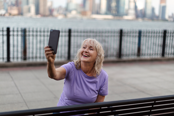 Woman taking a selfie outdoors after successful clinician-guided weight loss journey